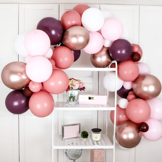 a white shelf topped with lots of balloons