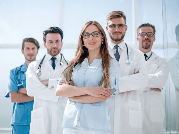 a group of doctors standing in front of a glass wall with their arms crossed and looking at the camera