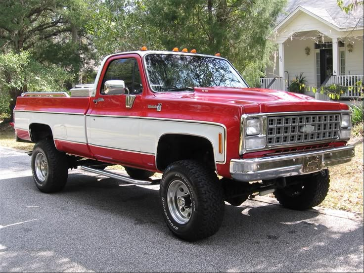 a red and white truck parked in front of a house