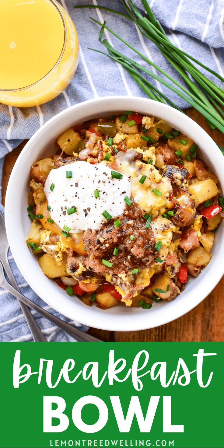 a bowl filled with potatoes, meat and cheese next to a glass of orange juice