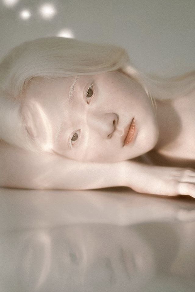 a woman with white hair laying on the floor