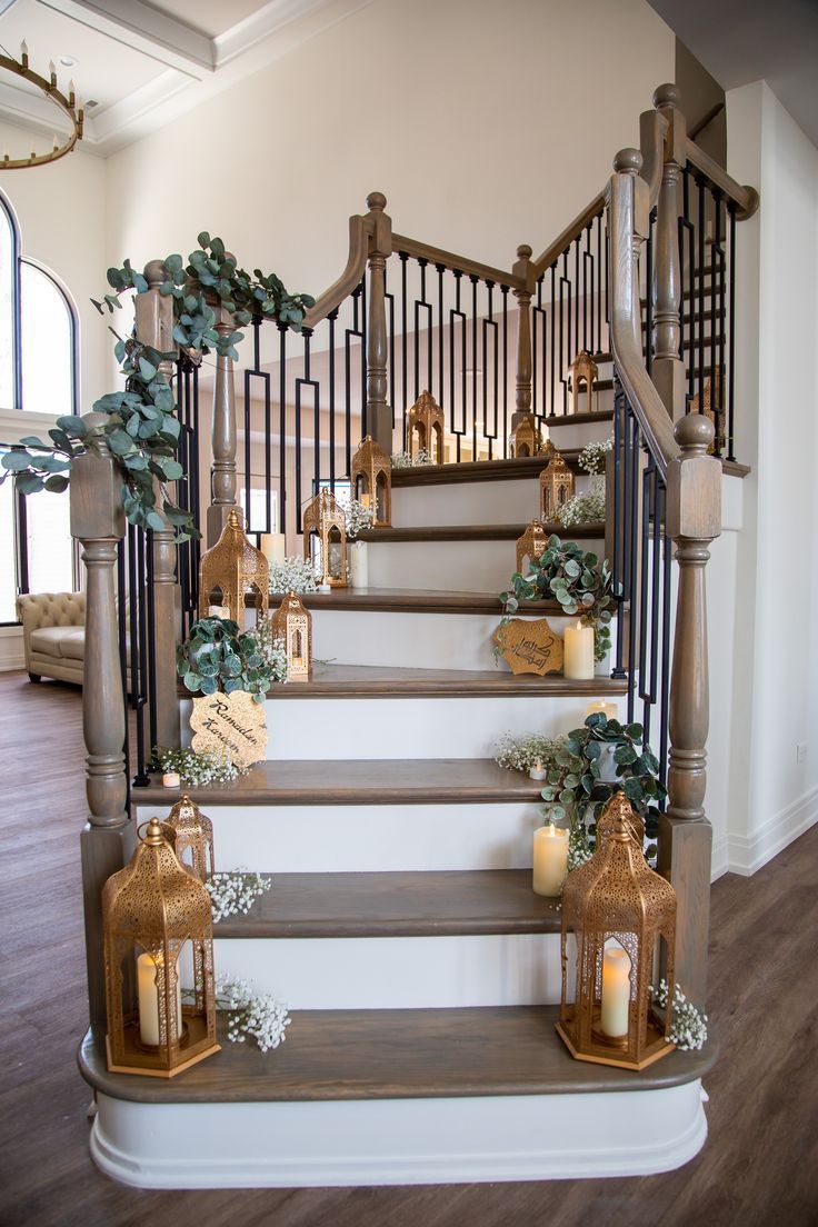 a set of stairs with candles and greenery on the bannister railings