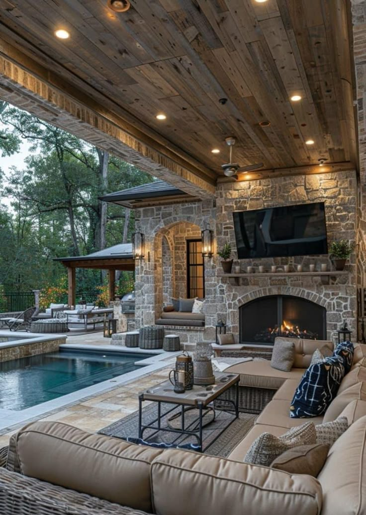 a living room with couches and a fireplace next to a swimming pool