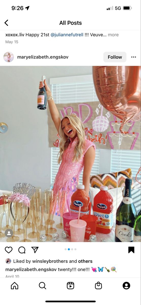 a woman standing in front of a table filled with drinks and confetti bottles