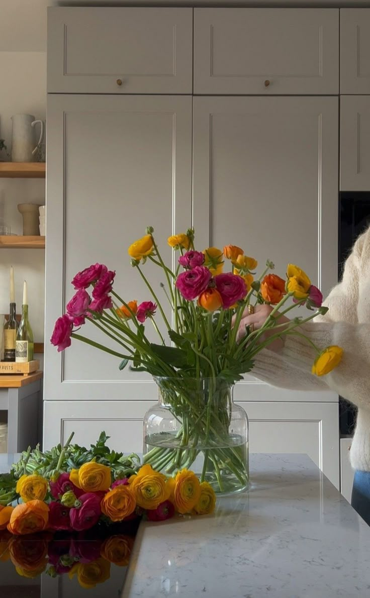 a vase filled with flowers sitting on top of a counter