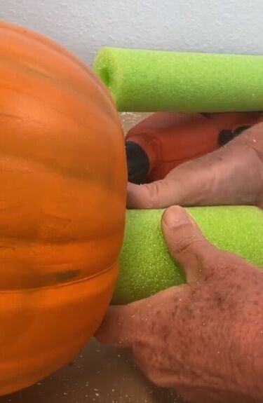 an older man is using foam to make a pumpkin with his hands on the ball