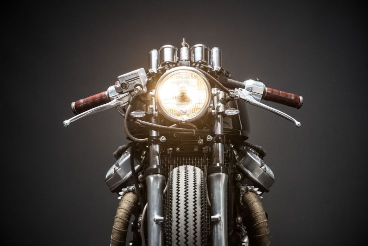 the front end of a motorcycle with lights on it's headlight and handlebars