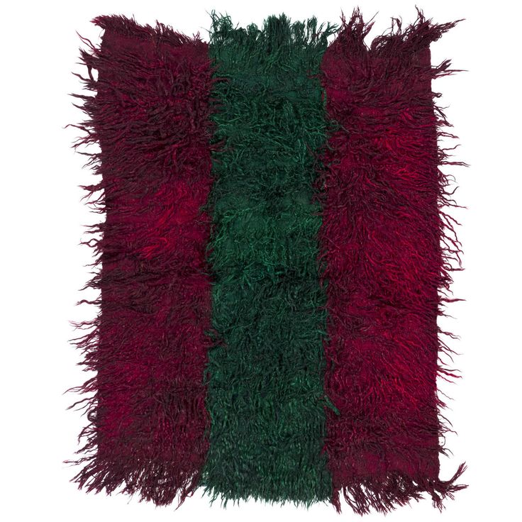 a red and green rug with fringes on it's sides, against a white background