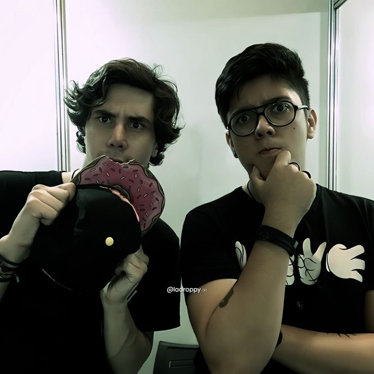 two young men standing in front of a mirror