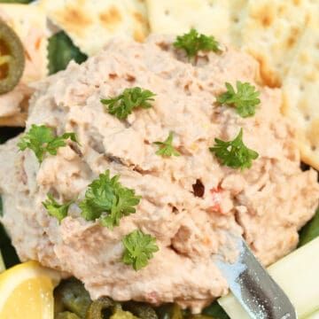 a close up of a plate of food with crackers and lemon wedges on it