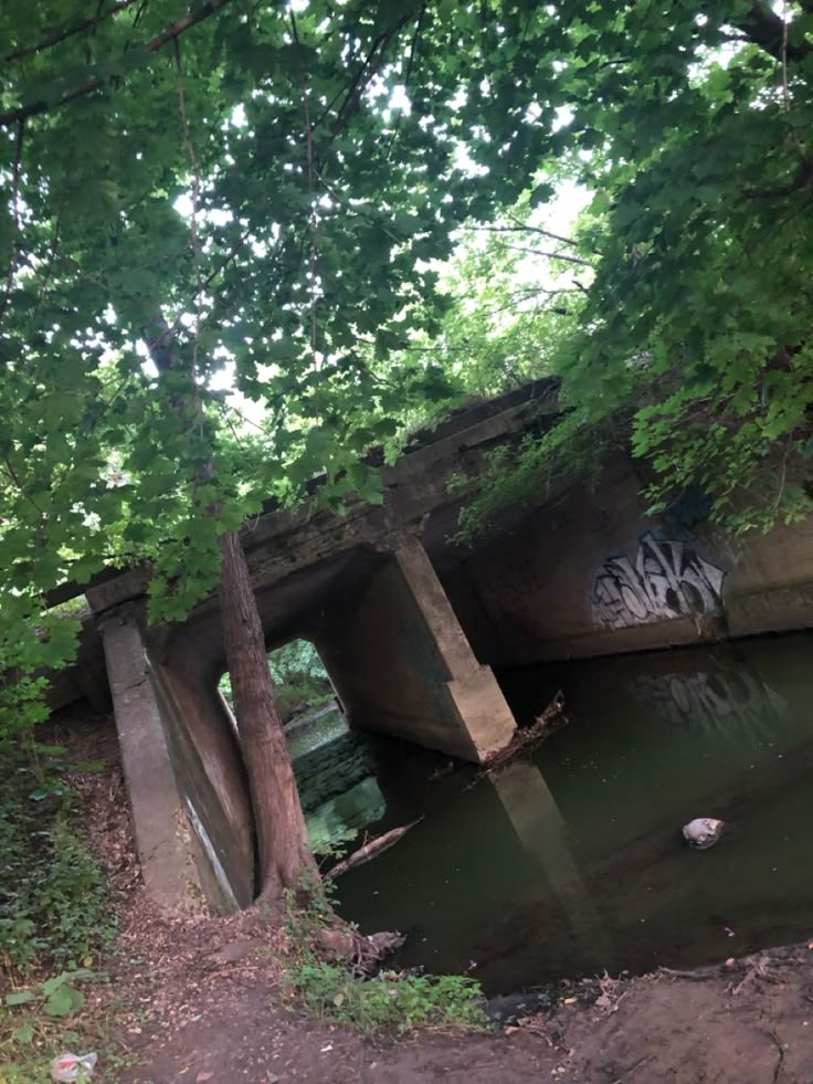 an old concrete bridge over a small river