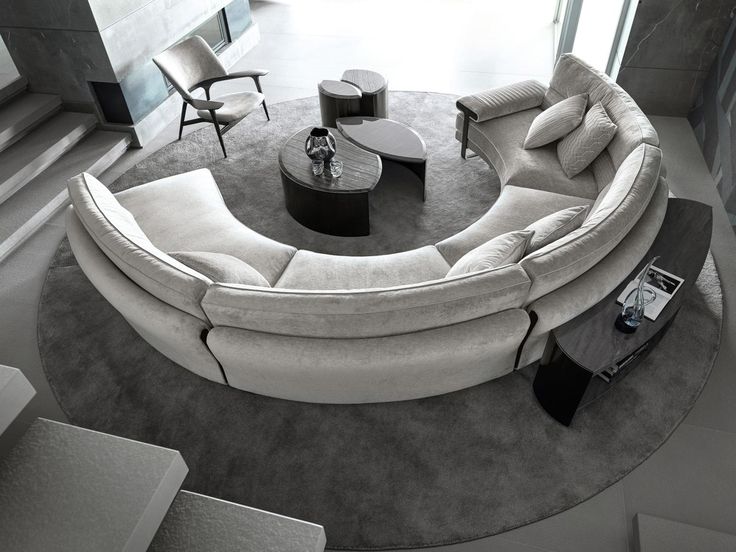 a circular couch sitting on top of a rug in a living room