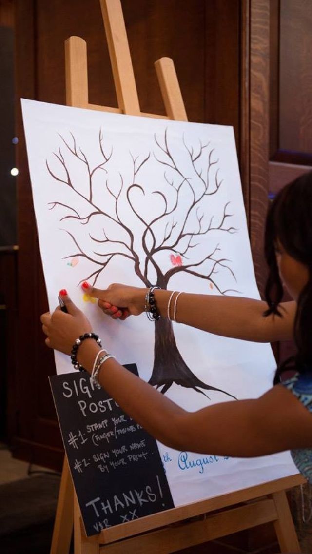 a woman is painting a tree on an easel with chalk and pencils in front of her