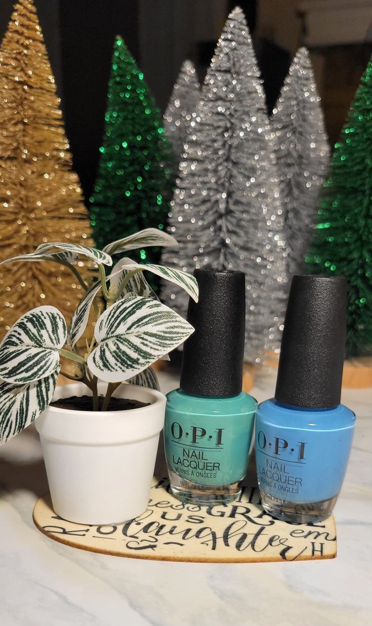 "O.P.I. brand nail polish on a heart-shaped board accented with a mini faux potted plant. A simple yet thoughtful gift.  .5fl oz. 2 each.  2 complimentary colors. 5 inches wide. 3 inches tall.  Colors: \"No Room for The Blues (blue)\" & \"My Dogsled Is a Hybrid (green)\"." Plant Makeup, Makeup Gifts, Nail Polish Gift, Opi Nail Lacquer, Makeup Gift, Complimentary Colors, Dog Sledding, The Blues, Nail Polishes