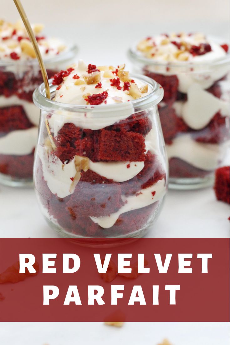 red velvet parfait with whipped cream and walnuts in a glass jar on a white table