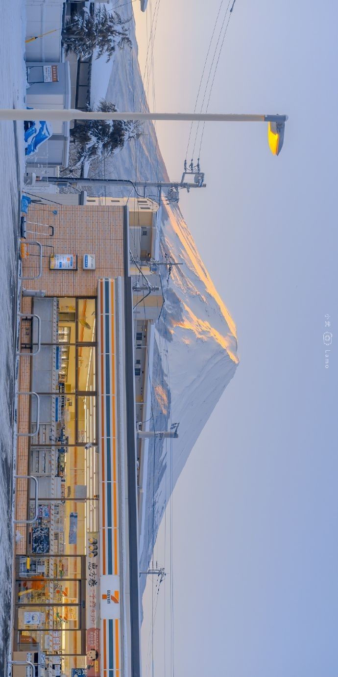 an overhead view of power lines and buildings in the background with snow on the ground