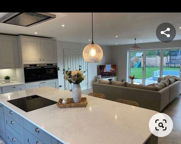 a large kitchen with an island in front of the living room and dining room area