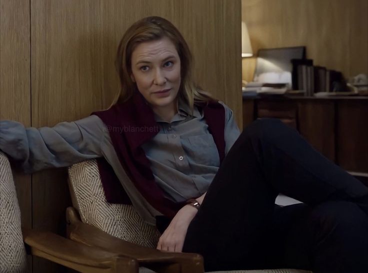 a woman sitting on top of a wooden chair