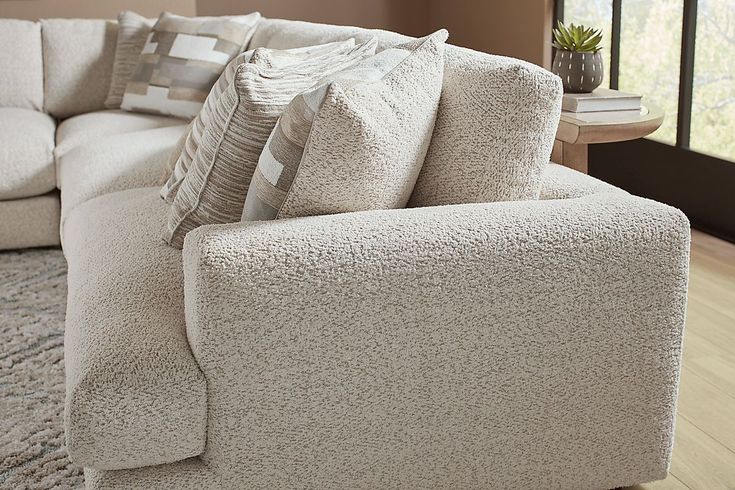 a white couch with pillows on it in a living room