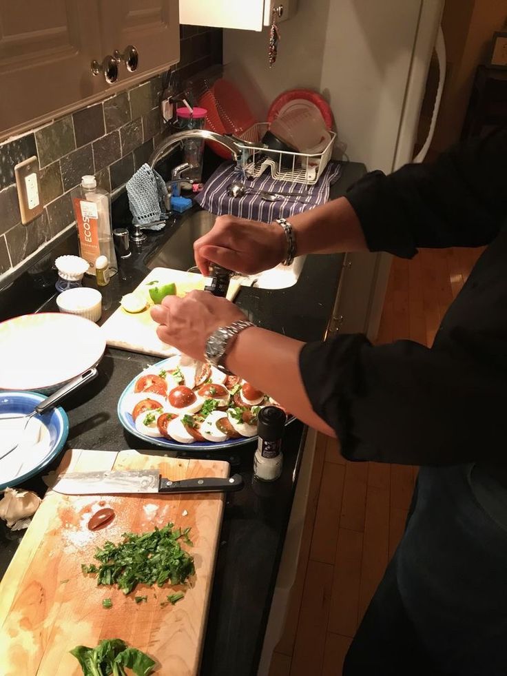 a person cutting up food on top of a kitchen counter