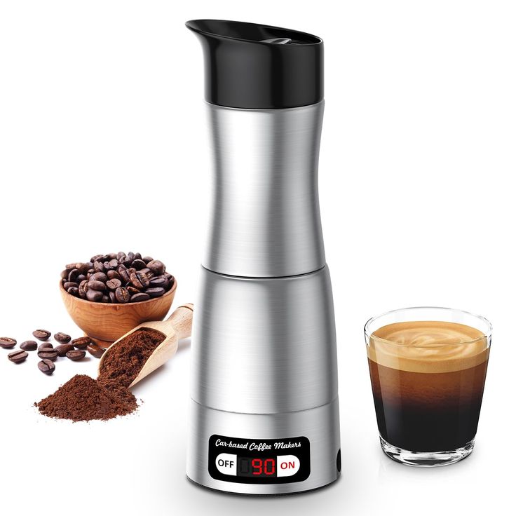 the coffee grinder is next to a cup of coffee and some beans on a white background