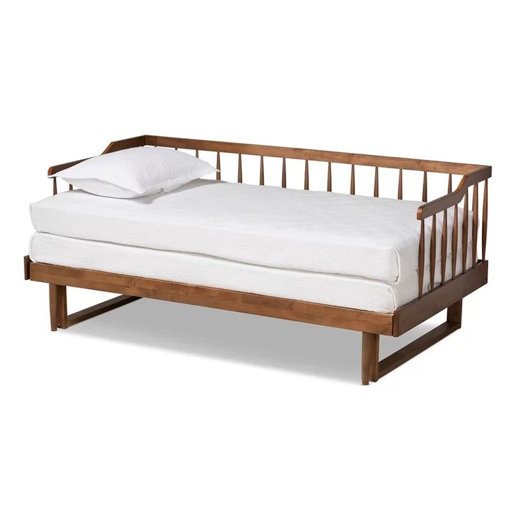 a wooden daybed with white sheets and pillows on it's sides, against a white background