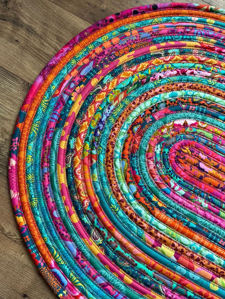 a multicolored round rug on a wooden floor