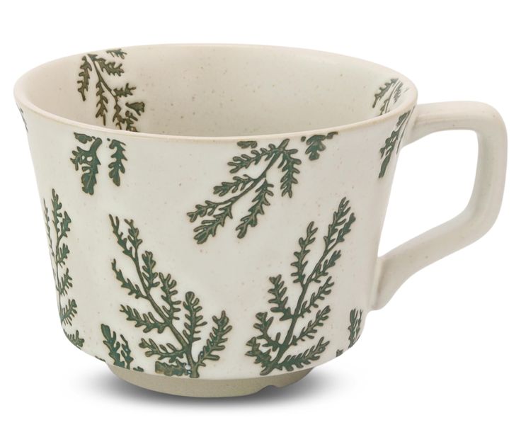 a white cup with green leaves on it