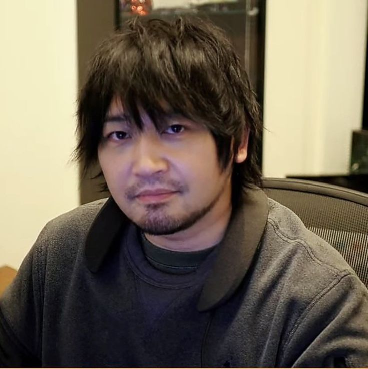 a man sitting in front of a computer monitor with his head turned to the side