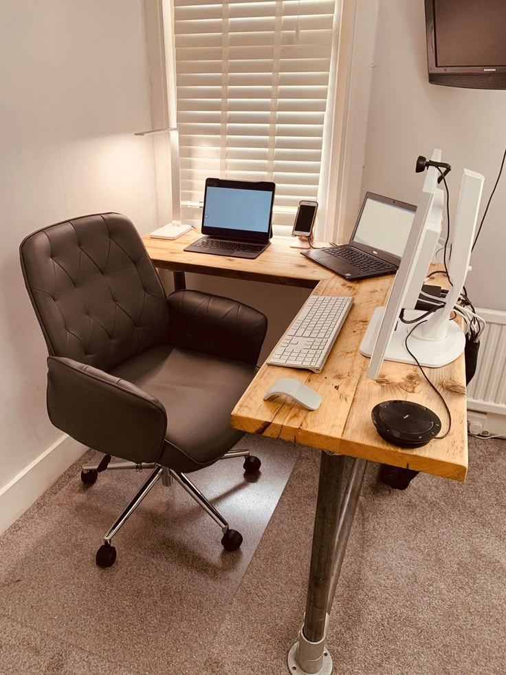 a desk with a chair, computer and laptop on it