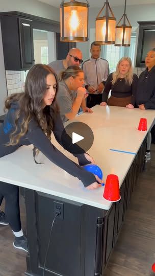 a group of people standing around a kitchen island with cones on it's legs