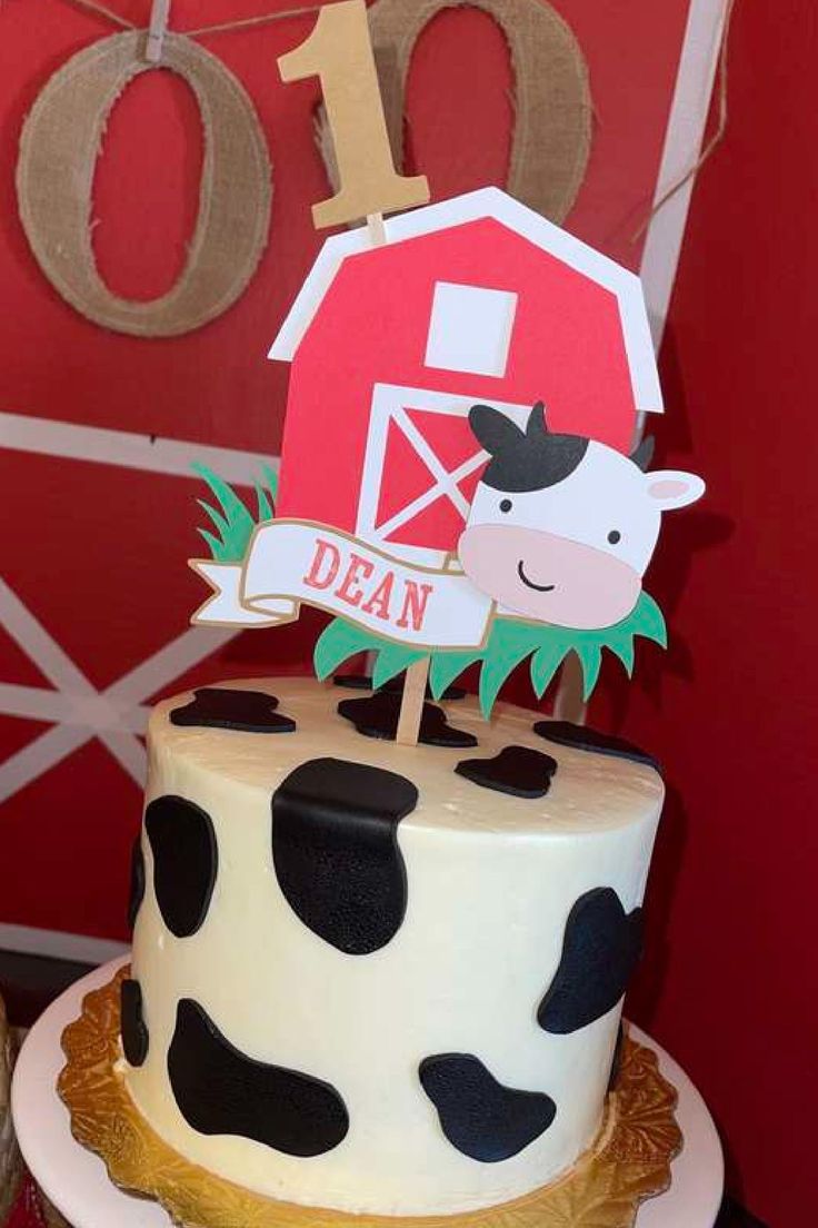 a birthday cake with a cow on top and a farm sign in the middle that says i do