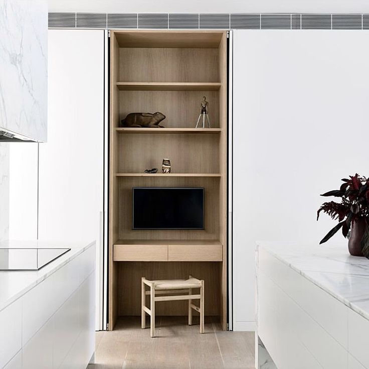 a living room with white walls and wooden shelves