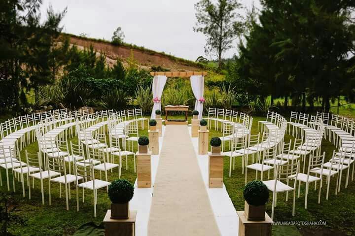 an outdoor ceremony setup with white chairs