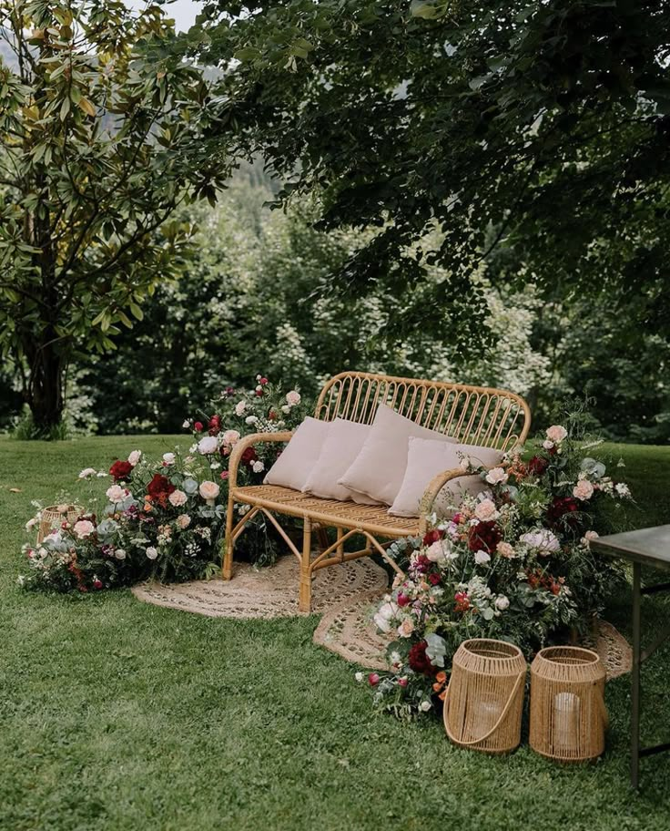 a wooden bench sitting in the middle of a lush green field next to flowers and plants