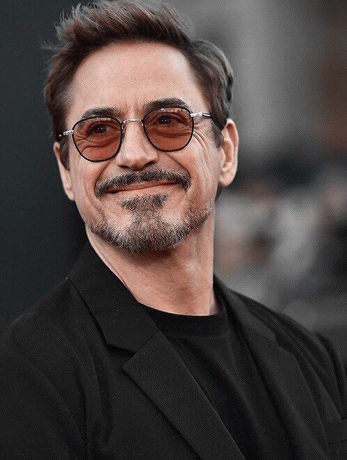 the avengers star is smiling and wearing his black suit with brown sunglasses on it's head