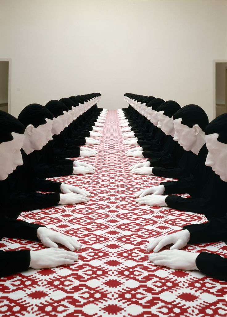 a group of people sitting on top of a red and white floor next to each other