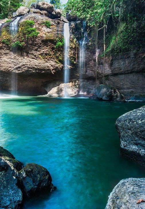 there is a large waterfall in the middle of this body of water with blue water