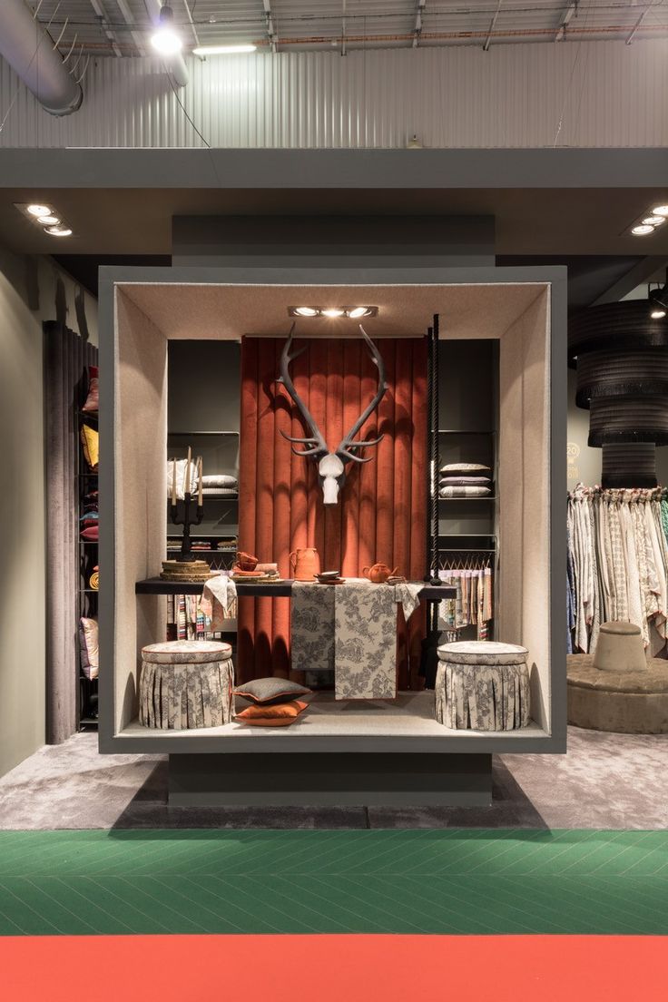 an open closet with clothes and deer head on the wall, in front of it