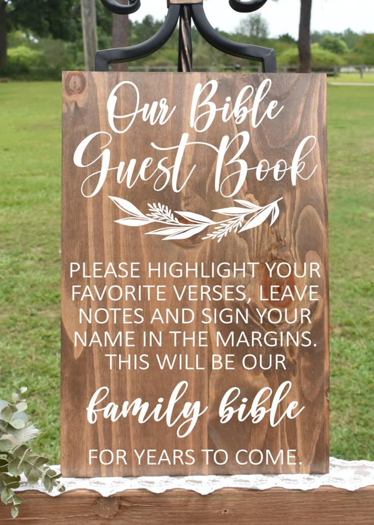 a wooden sign that says our bible guest book please hight your favorite verse, leave notes in the margings this will be our family bible for years to come