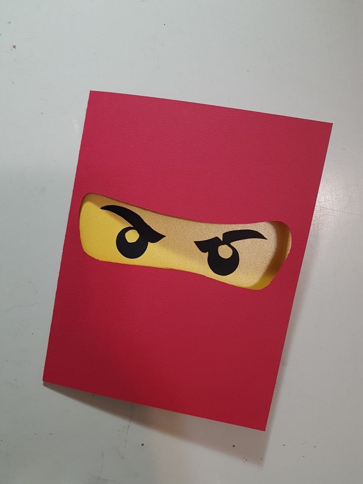 a close up of a piece of paper with a lego face cut out on it