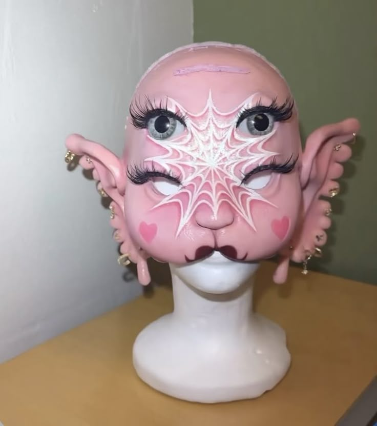 a white mannequin head with pink and white designs on it's face