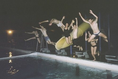 some people are doing tricks in the pool at night or onlookers watching