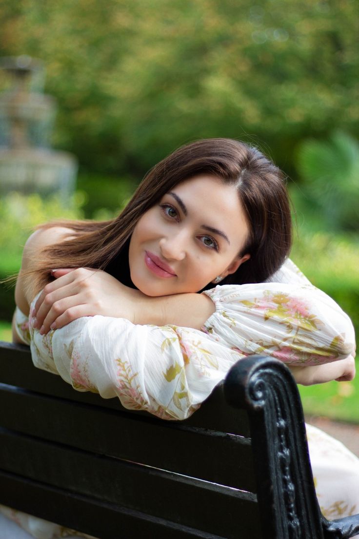 a woman sitting on top of a black bench