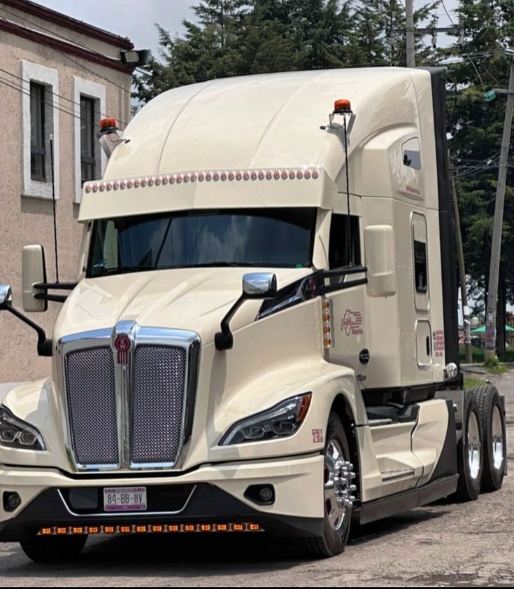 a white semi truck parked in front of a building