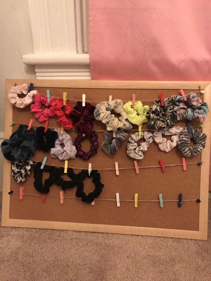 there are many small hair clips on the pegs in front of this bulletin board