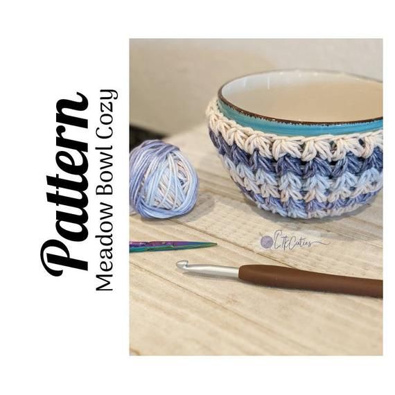 a crocheted bowl sits next to a ball of yarn and a knitting needle