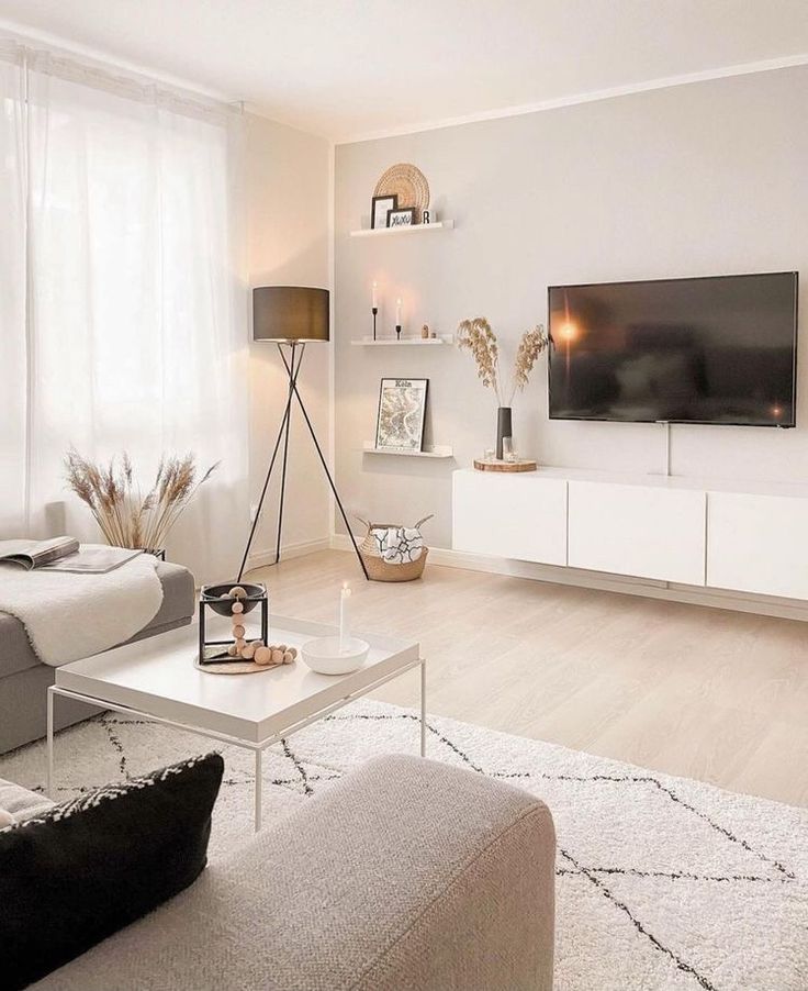 a living room filled with furniture and a flat screen tv mounted to the side of a wall