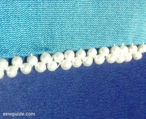 the beading is being sewn together with white beads