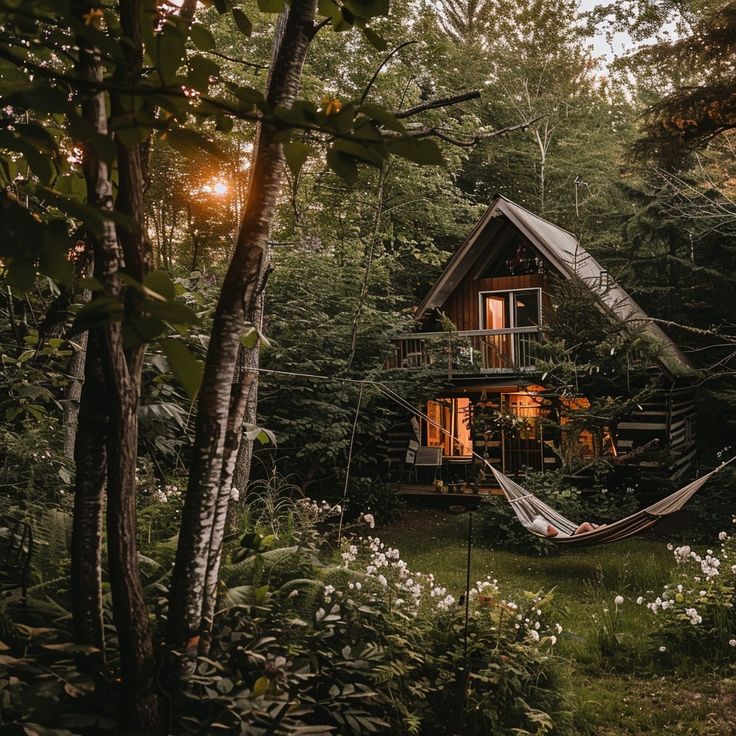 a house in the woods with a hammock hanging from it's roof